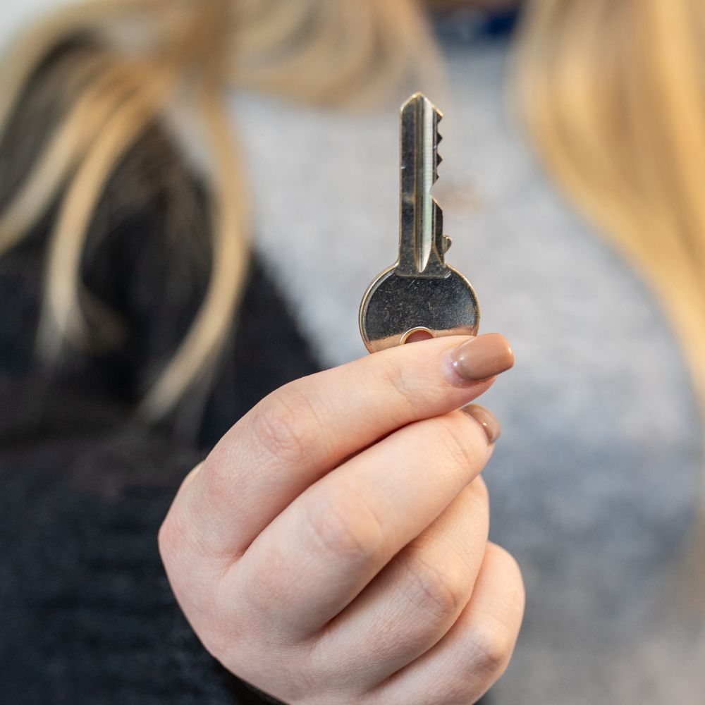 Female hand holding up a key